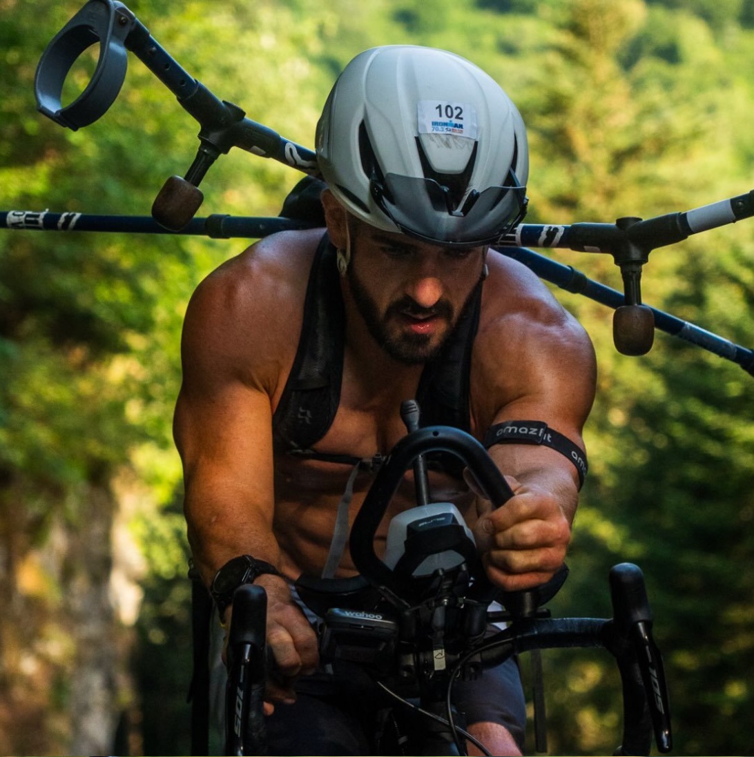 David van Wetherill racing an IRONMAN 70.3 bike leg with his crutches strapped across his back