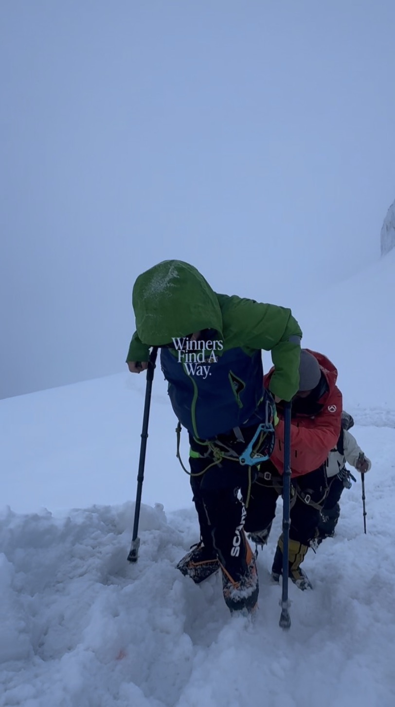 David climbing through snow on crutches with an expedition teammate