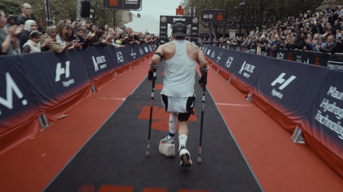 David on the IRONMAN 70.3 Bolton finish chute surrounded by cheering crowds